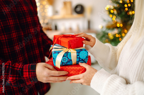 Gives the gift. Exchanging the christmas presen. Man giving christmas present to his girlfriend. Winter holiday, New Year, celebration, birthday concept.