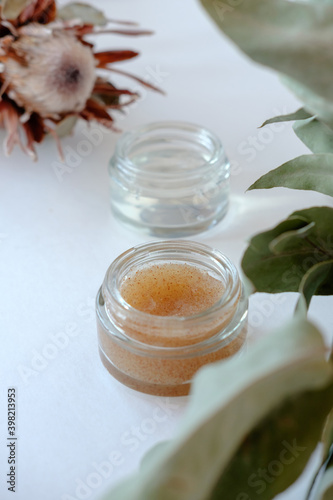 Two jars with cosmetics on a light background. Scrub and moisturizing gel for skin care
