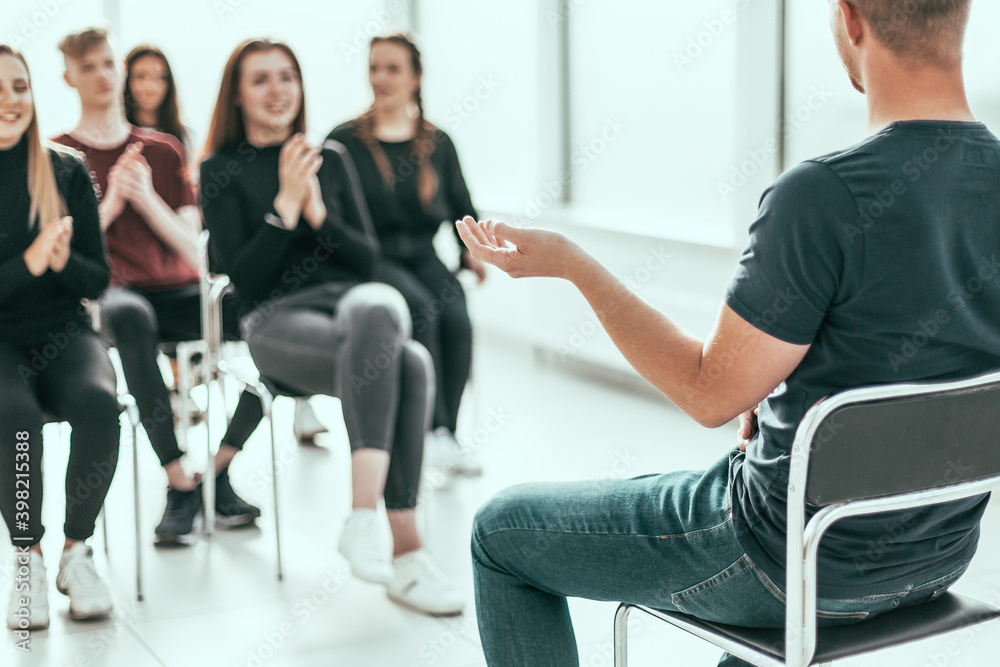 group of diverse young people applauding the business speaker .