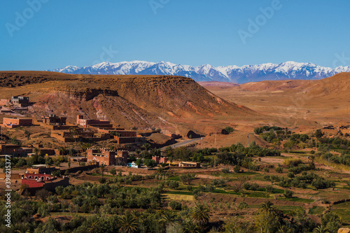 Village Tamedakhte with its oasis, in the background the snow covered summits of mountain Atlas