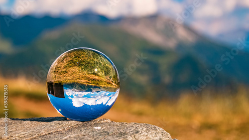 Crystal ball alpine summer landscape shot at the famous Timmelsjoch high alpine road, Dolomites, South Tyrol, Italy