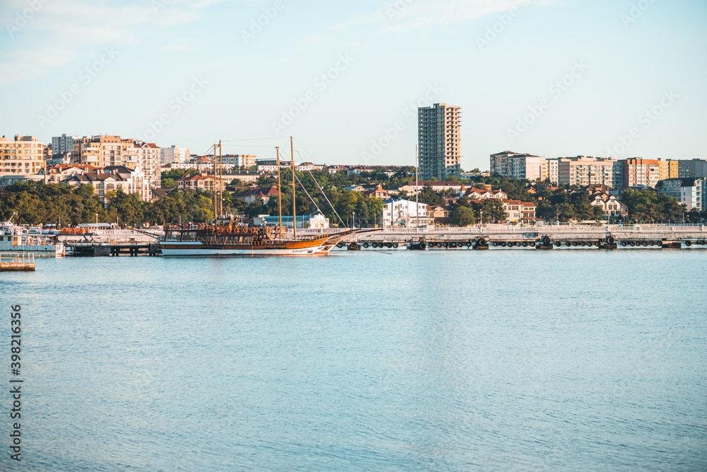 Gelendzhik, Russia, 27 May 2020: Resort city and central pier with standing pleasure ships and yachts in Black sea bay in summer day.