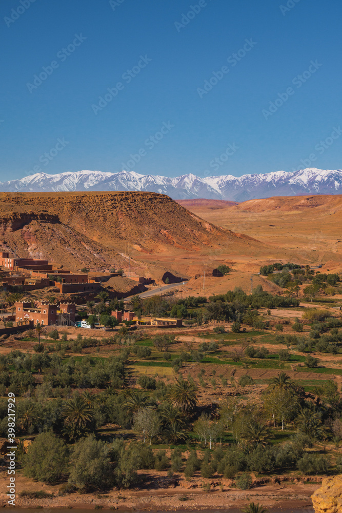 Village Tamedakhte with its oasis, in the background the snow covered summits of mountain Atlas