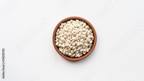 white beans in brown ceramic bowl. bowl of white kidney beans. navy, cannellini bean on white background isolated top view photo