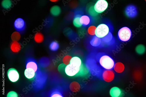 bright multicolored Christmas lights bokeh and snowflake pattern