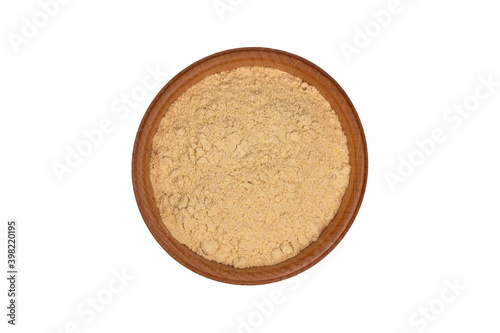 Bio organic dried ginger powder in wooden bowl