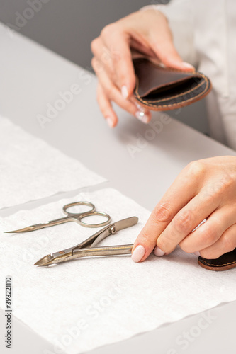 Manicurist's hands lay down manicure tools on table preparing for manicure procedures