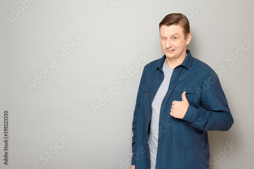 Portrait of happy proud mature man raising thumb up and winking