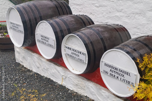 Four different sized whisky barrels for maturation. They have a description on them with the name and the size in litres. photo