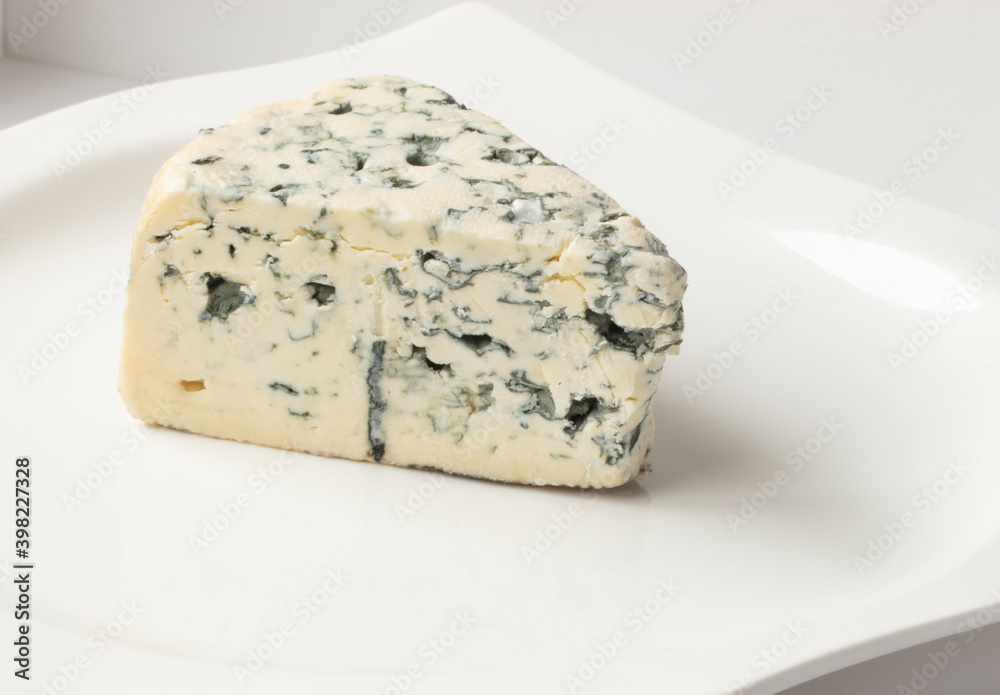  Queso Cabrales en plato sobre fondo blanco, aperitivo, vista cenital. Cabrales cheese on a plate on a white background, appetizer, overhead view.