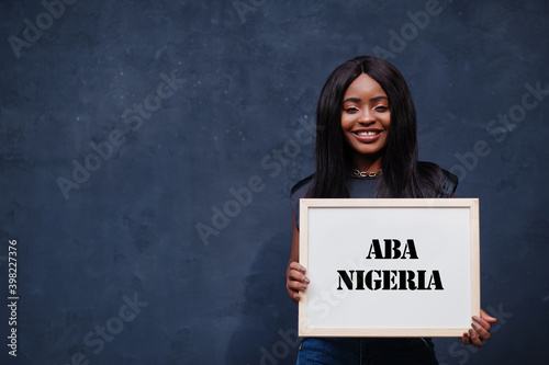 African woman hold white board with Aba Nigeria inscription. Most populous city in Africa concept.