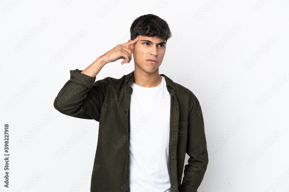 Young man over isolated white background making the gesture of madness putting finger on the head Young man over isolated white background making the gesture of madness putting finger on the head