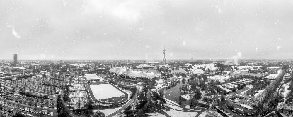 Snowflakes over Munich, the bavarian city in winter with the panoramic view over the Olympic Park, snow covered.
