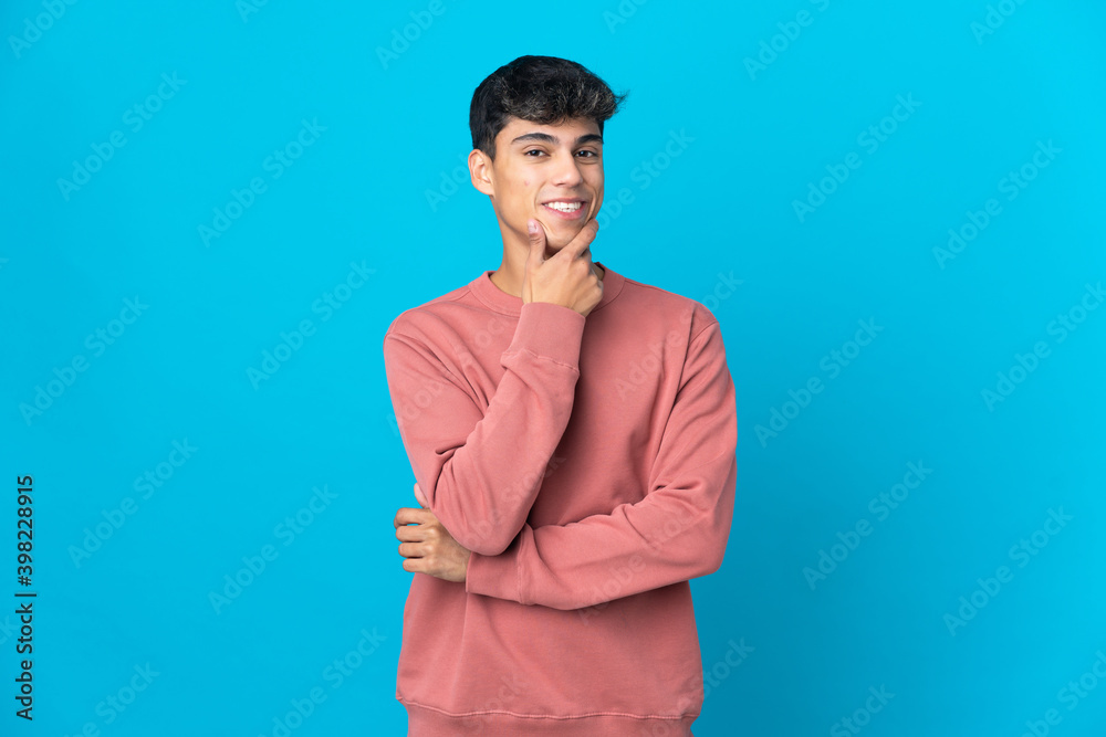 Young man over isolated blue background happy and smiling Young man over isolated blue background happy and smiling
