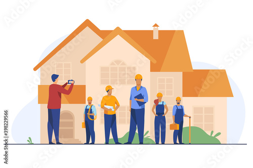 Builders team posing for photo in front of house. Worker, helmet, camera flat vector illustration. Construction or architecture concept for banner, website design or landing web page