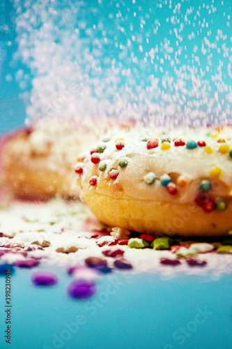 Donut sprinkled with powdered sugar on a blue background