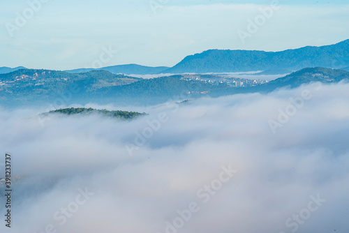 Fototapeta Naklejka Na Ścianę i Meble -  Many houses in in the mist in the morning. Early morning fog and mist burns off over large houses nestled in green rolling hills