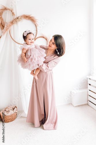 happy young mother holding and playing with her baby