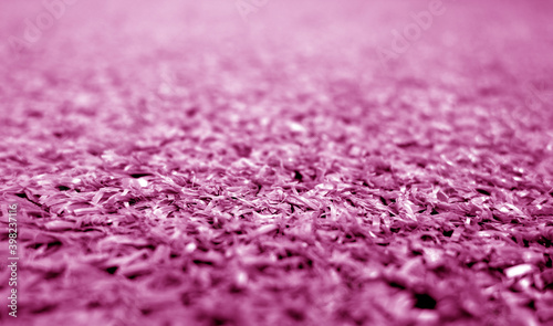 Pink color artificial grass close-up with blur background