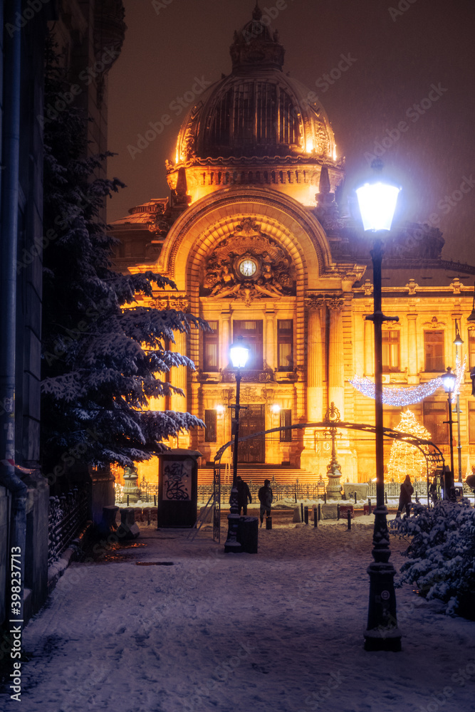 Winter in Bucharest, snowfall in the capital of Romania during the night, view from landmarks of the city and Christmas lights