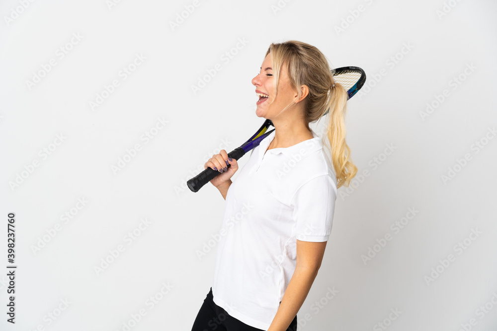 Young Russian woman tennis player isolated on white background laughing in lateral position Young Russian woman tennis player isolated on white background laughing in lateral position