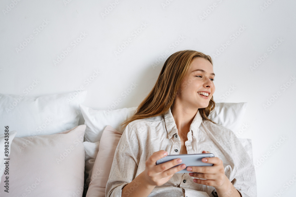 Beautiful smiling nice girl playing video game on cellphone Beautiful smiling nice girl playing video game on cellphone