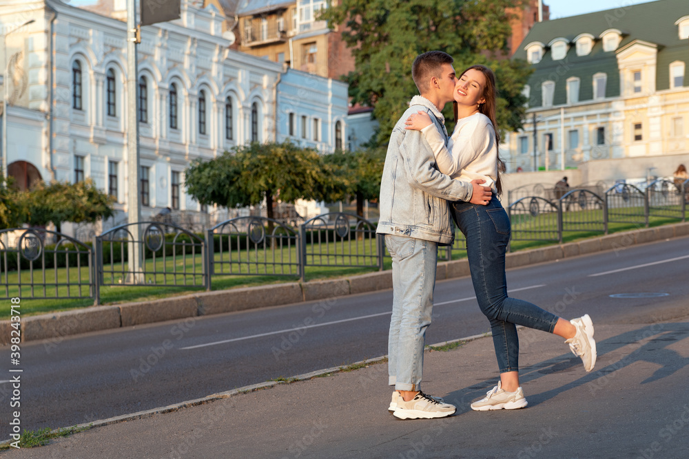 Happy young couple kissing on street. Tenderness, love, care