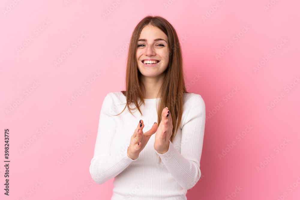 Young woman over isolated pink background applauding after presentation in a conference Young woman over isolated pink background applauding after presentation in a conference
