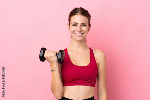 Fototapeta Naklejka Na Ścianę i Meble -  Young sport woman over isolated pink background making weightlifting