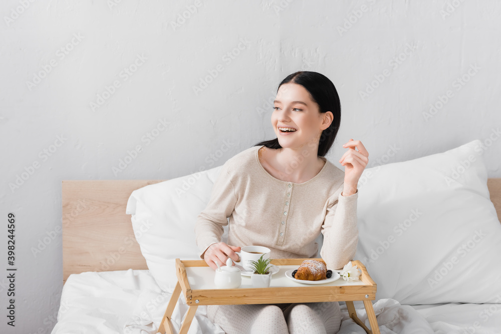 happy woman with vitiligo laughing near breakfast on tray happy woman with vitiligo laughing near breakfast on tray