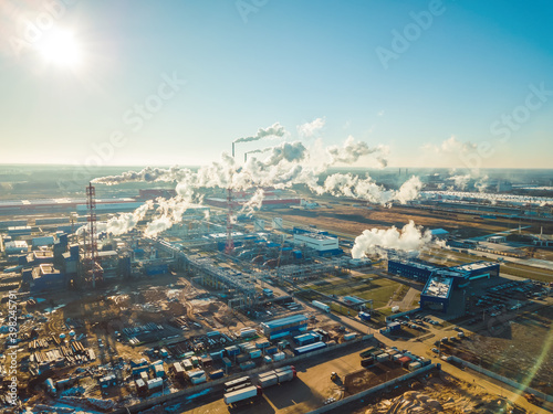 Factories  pipes with smoke on a Sunny snowless winter day close up  photo from a drone. Concept of ecology and nature protection