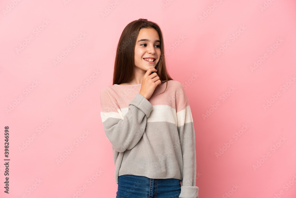 Little girl isolated on pink background looking to the side and smiling Little girl isolated on pink background looking to the side and smiling