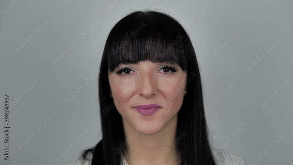 Confident smiling young adult woman looking at camera standing over white background. Happy millennial casual professional smile Confident smiling young adult woman looking at camera standing over white background. Happy millennial casual professional smile