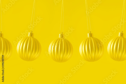 hanging Christmas baubles on a pastel background toned trendy color