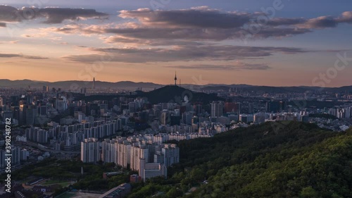 Zoom in, Time lapse 4K Seoul city skyline and Seoul tower modern building and architecture, Beautiful clouds flow through in Seoul, South Korea. photo