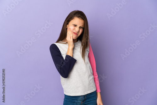 Little girl isolated on purple background with toothache