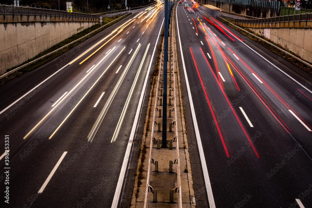 Overhaul with red car light trails on a motorway in night dawn