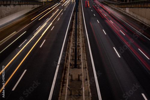Overhaul with red car light trails on a motorway in night dawn
