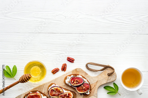 Sandwiches with cheese  fresh figs and walnuts on wooden cutting board