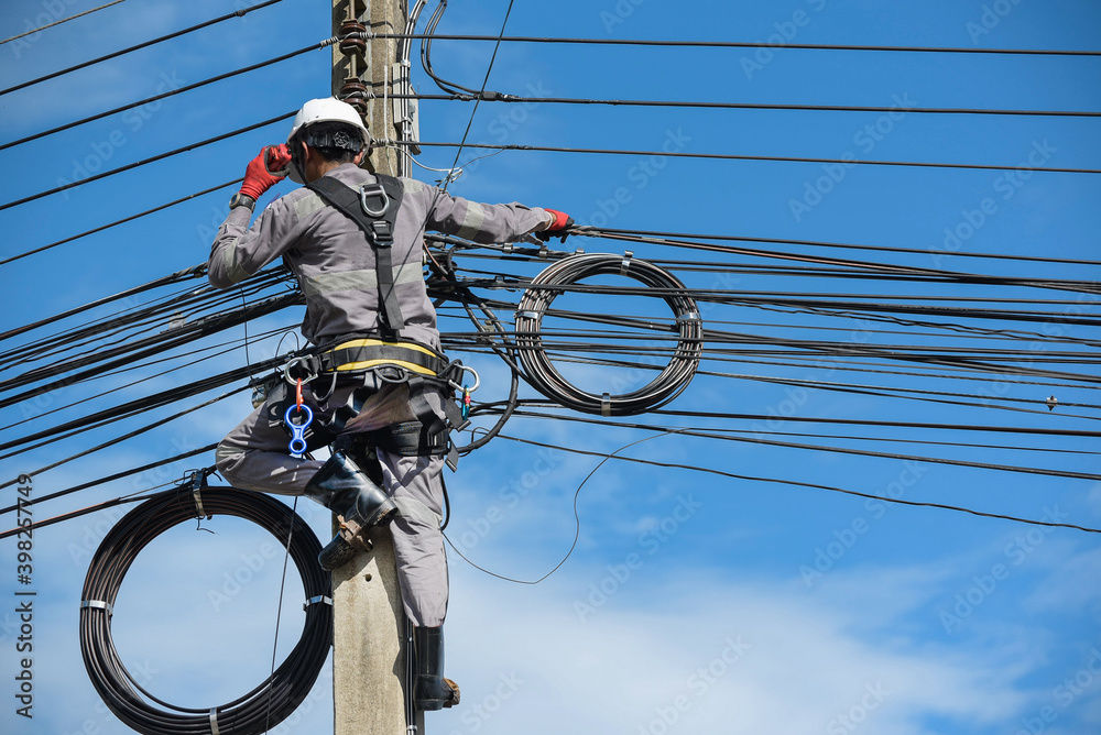 Electricians carry radio walkie talkie communications on poles to maintain highvoltage lines on