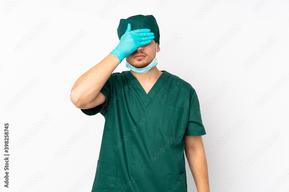Surgeon in green uniform isolated on isolated white background covering eyes by hands. Do not want to see something Surgeon in green uniform isolated on isolated white background covering eyes by hands. Do not want to see something