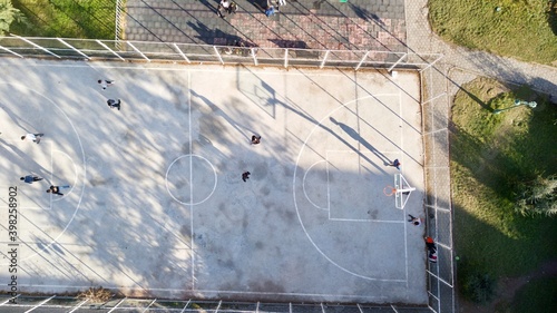 aerial view of street basketball court and children playground. kids are playing football at the sunset.