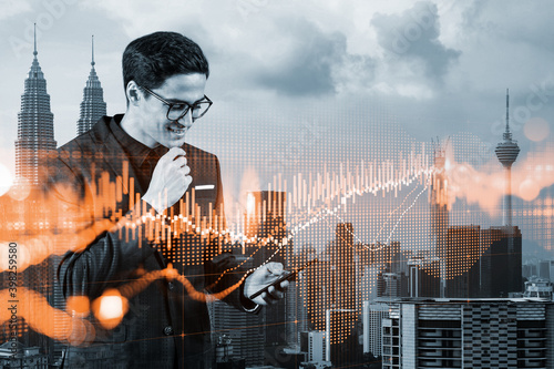 Handsome eastern trader checking quotes to forecast the capital market behavior. Concept of trading strategy. Forex chart. Kuala Lumpur. Double exposure.