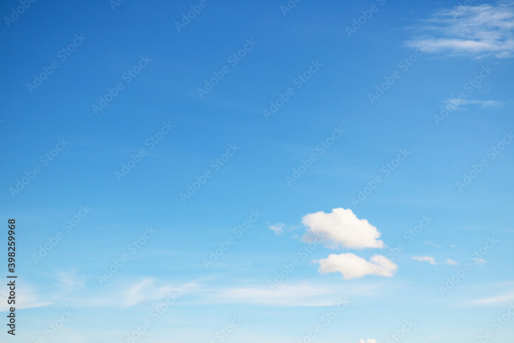 Small, fluffy and lonely clouds in the blue sky with copy space for texture background