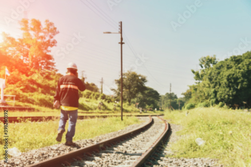 Engineers work together using smartphones near the railroads wearing helmets in retro filter tones.