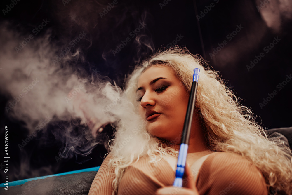 Beautiful Girl smoking hookah in Exhaling smoke. Sexy girl
