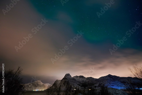 Aurora borealis Green northern lights above mountains