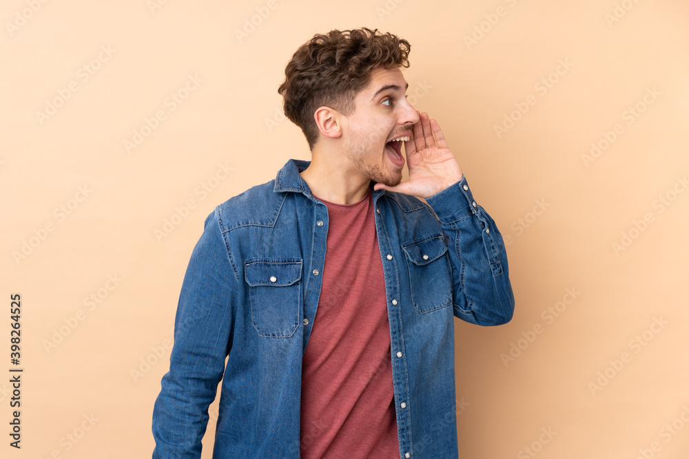 Caucasian man isolated on beige background shouting with mouth wide open