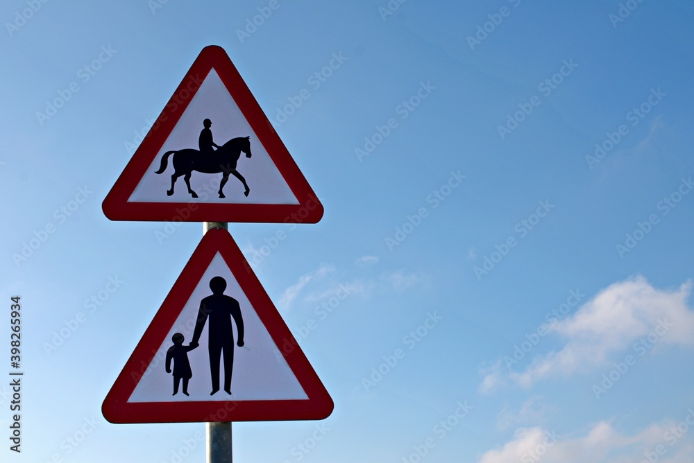 Accompanied Horses with Parent and child road signs, blue cloudy sky. Accompanied Horses with Parent and child road signs, blue cloudy sky.