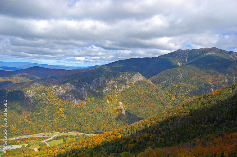 Fototapeta premium Franconia Notch with fall foliage and Highway I-93 aerial view from top of the Cannon Mountain in Franconia Notch State Park in White Mountain National Forest, near Lincoln, New Hampshire NH, USA. 